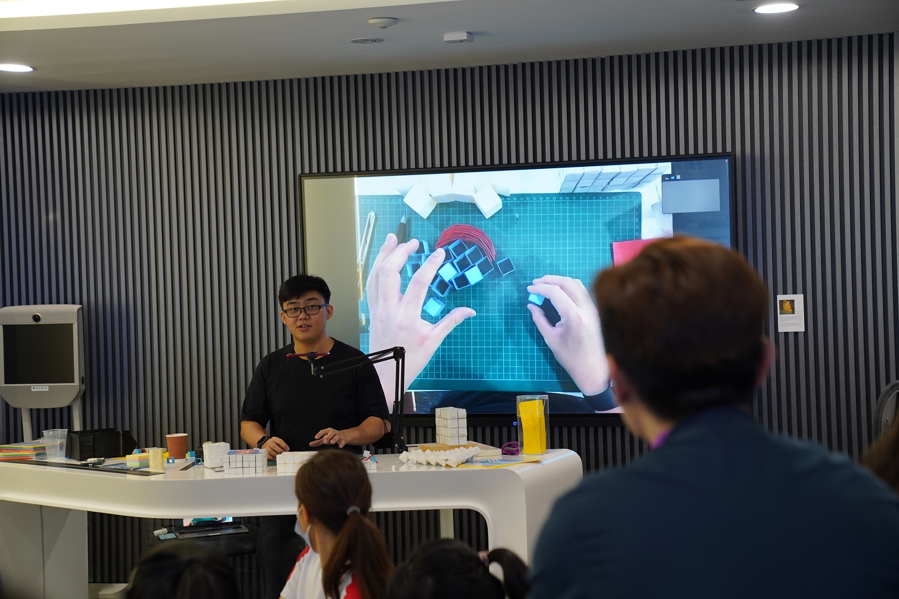 Zi Hao, from Para ( ) Studios conducting a hands-on workshop on constructing kinetic Kirigami sculptures.
