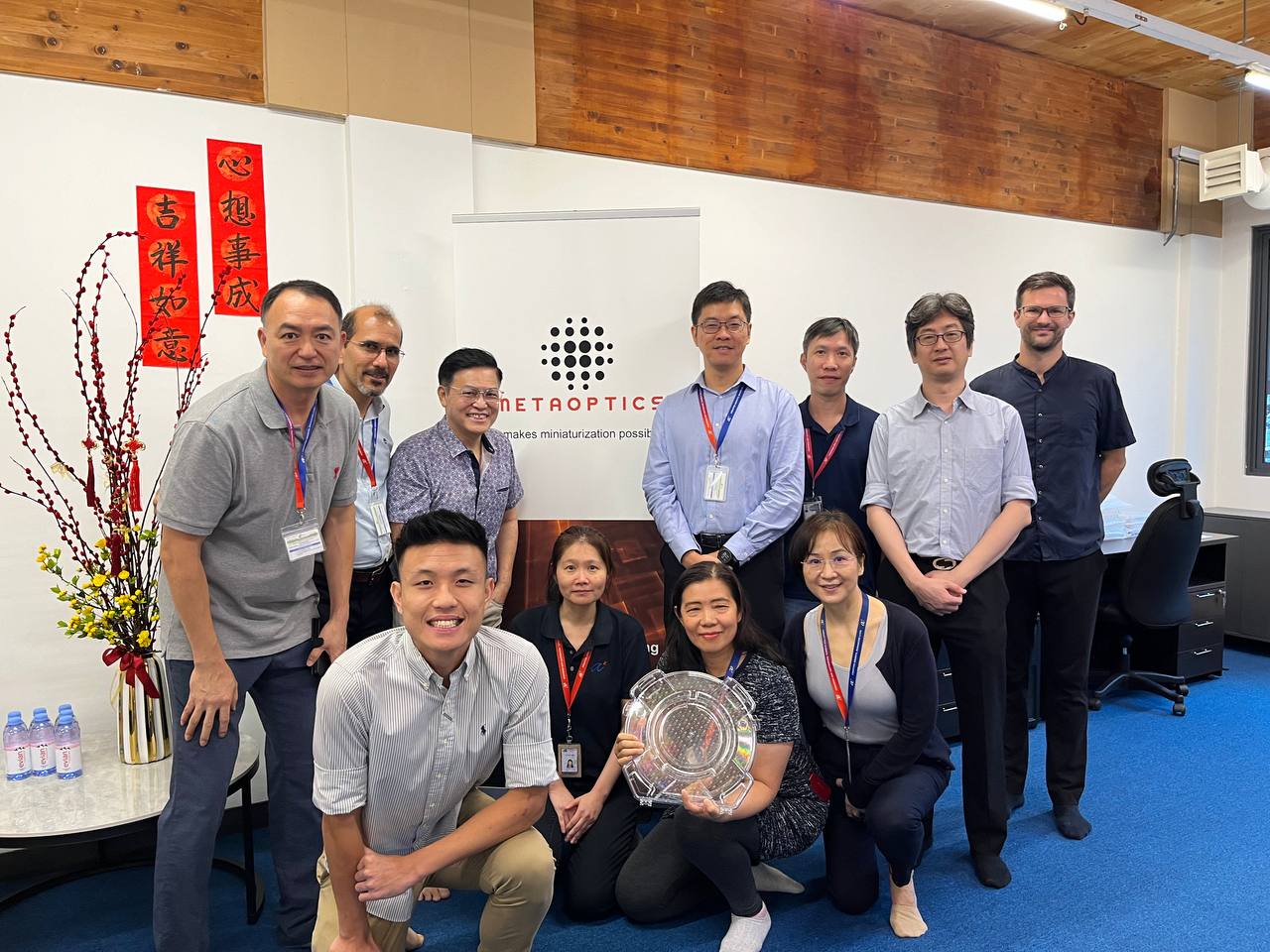 The team from MetaOptics Technologies, IME and IMRE with the 12-inch glass wafer in a holding case